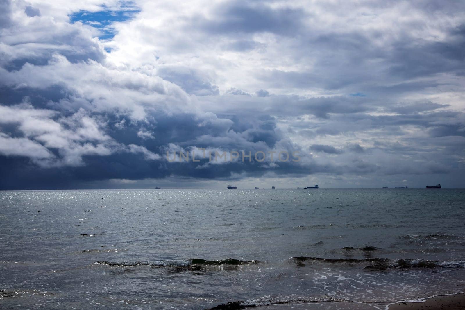 Dramatic seascape in dark colors. Dark sky with clouds over the stormy sea. High quality photo
