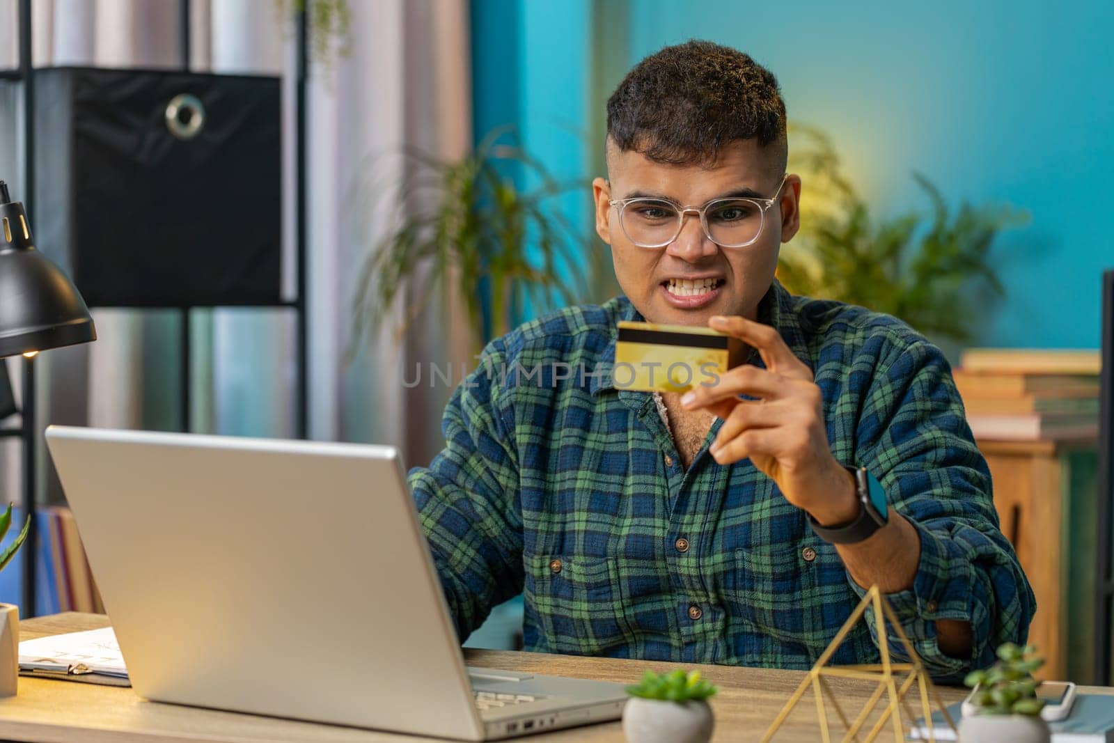 Angry mad stressed freelancer try to pay online shopping with laptop blocked credit card smartphone. Annoyed man guy buying bank refuse problem unsuccessful payment lack of money balance. Lifestyle