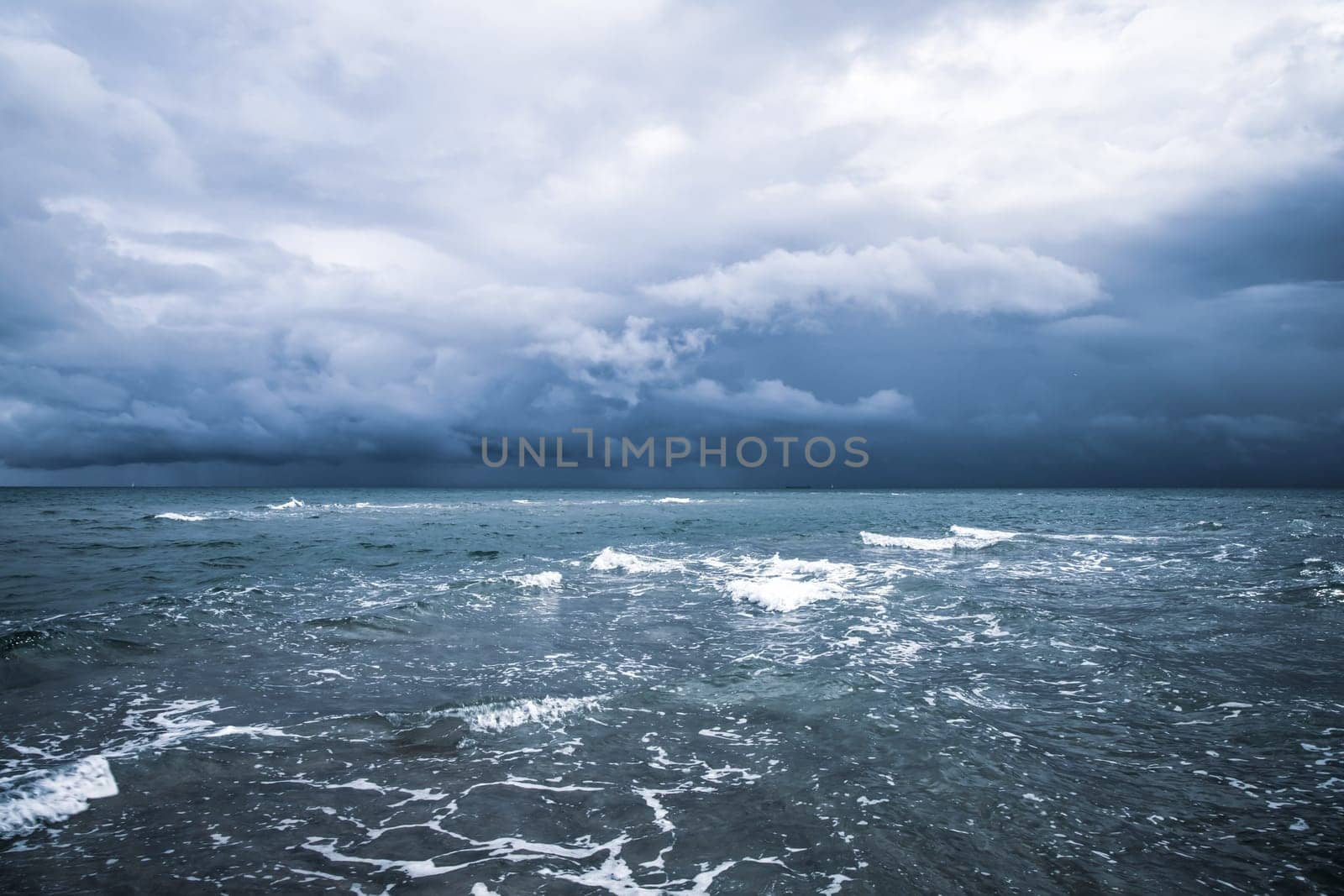 Dramatic seascape in dark colors. Dark sky with clouds over the stormy sea. High quality photo
