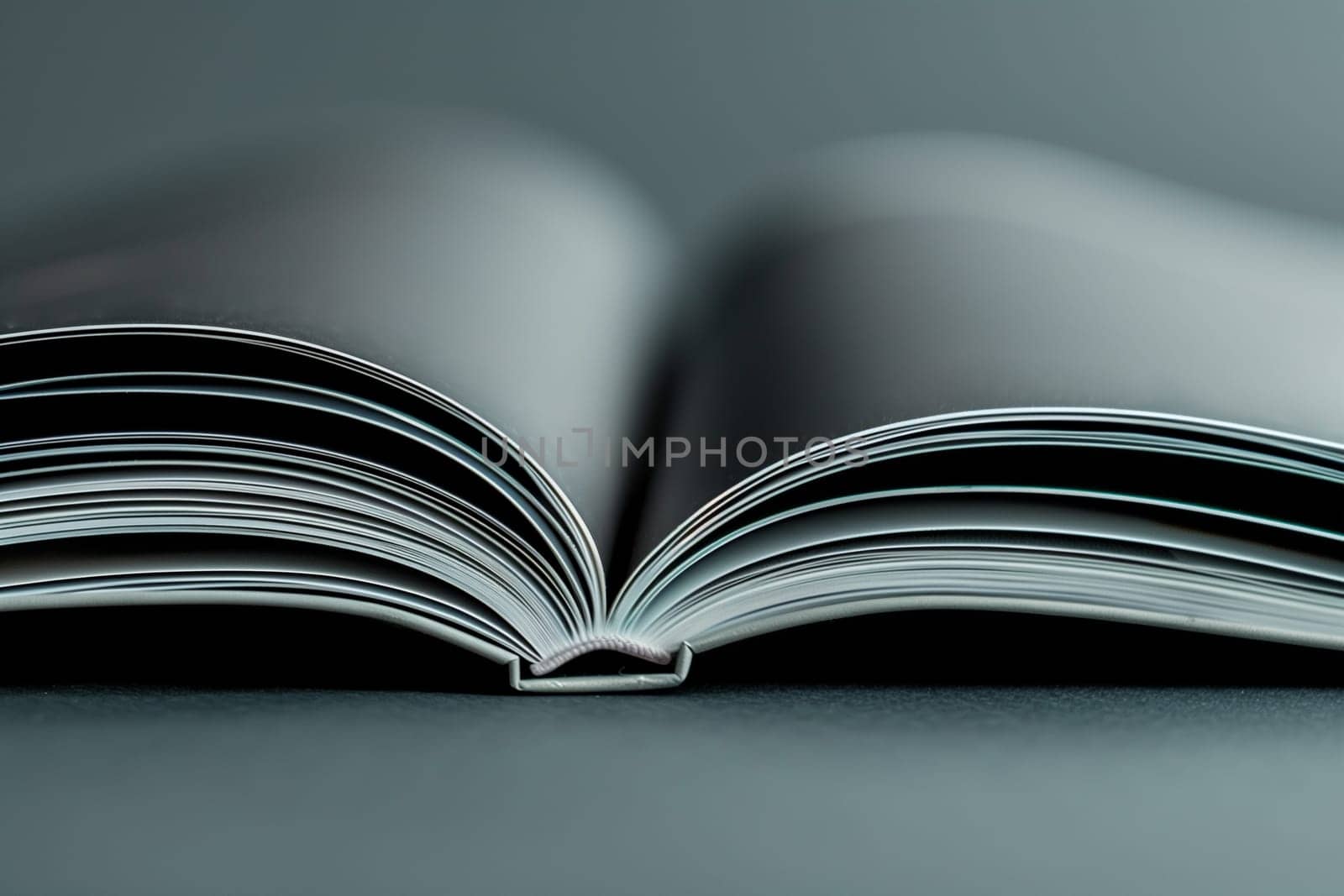 An open book resting on a plain grey background, showcasing its pages and cover.