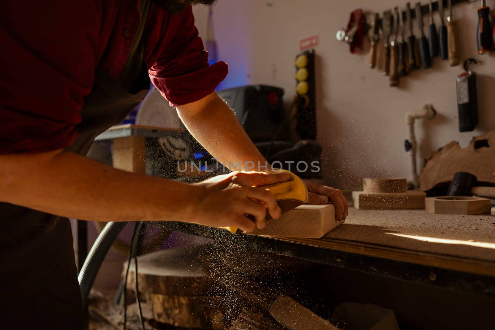 Woodworking expert using sandpaper to sander wood, making wooden products by DCStudio