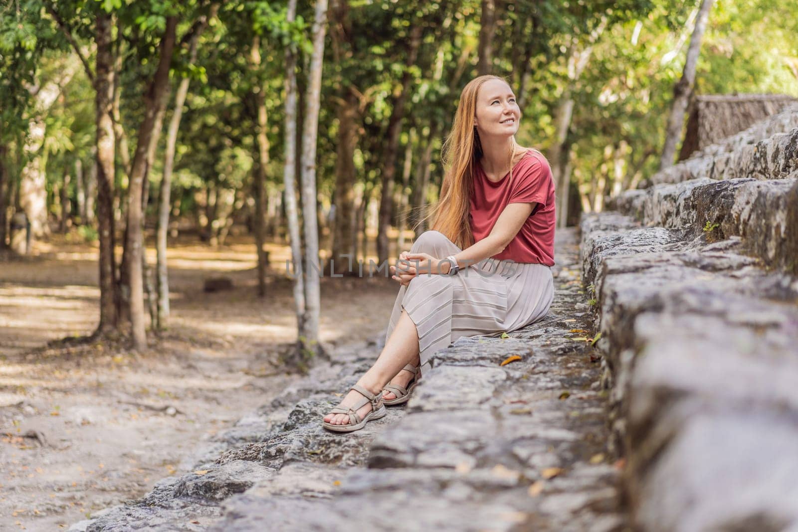 Woman tourist at Coba, Mexico. Ancient mayan city in Mexico. Coba is an archaeological area and a famous landmark of Yucatan Peninsula. Cloudy sky over a pyramid in Mexico.