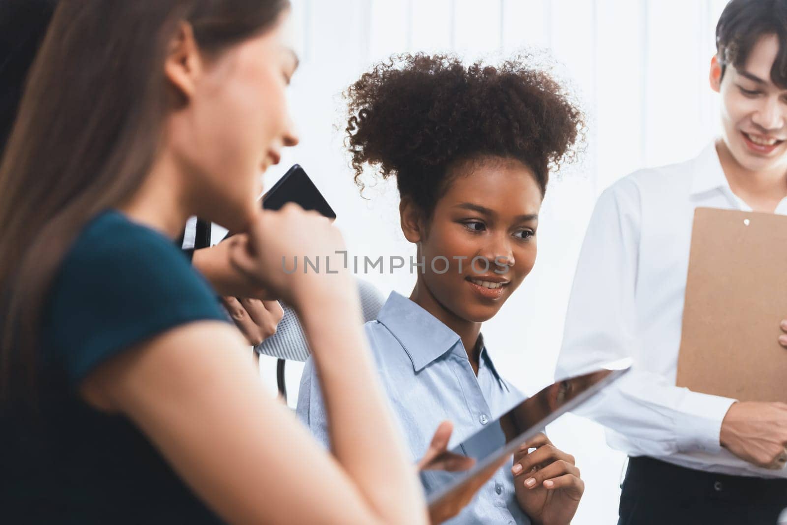 Young african businesswoman working together and discussing in corporate office with multicultural coworkers. Professional and diversity teamwork discuss business plan on desk. Concord
