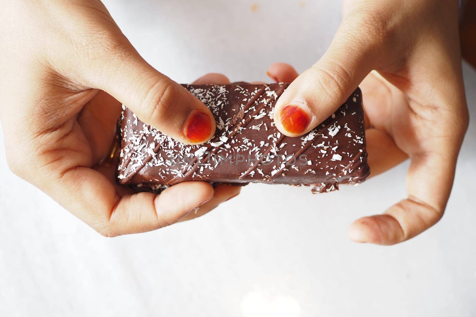 woman holding a coconut protein bar.