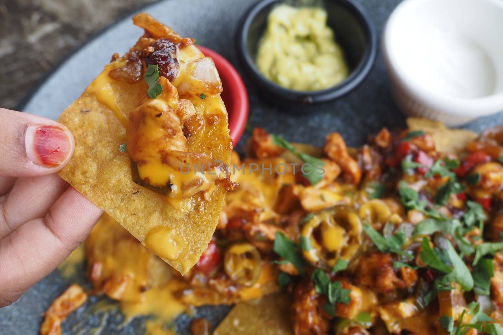 Corn chips nachos with fried meat on table