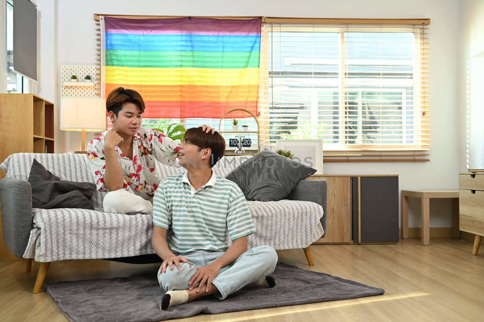 Relaxed Asian gay couple enjoy conversation and spending leisure time together at home.