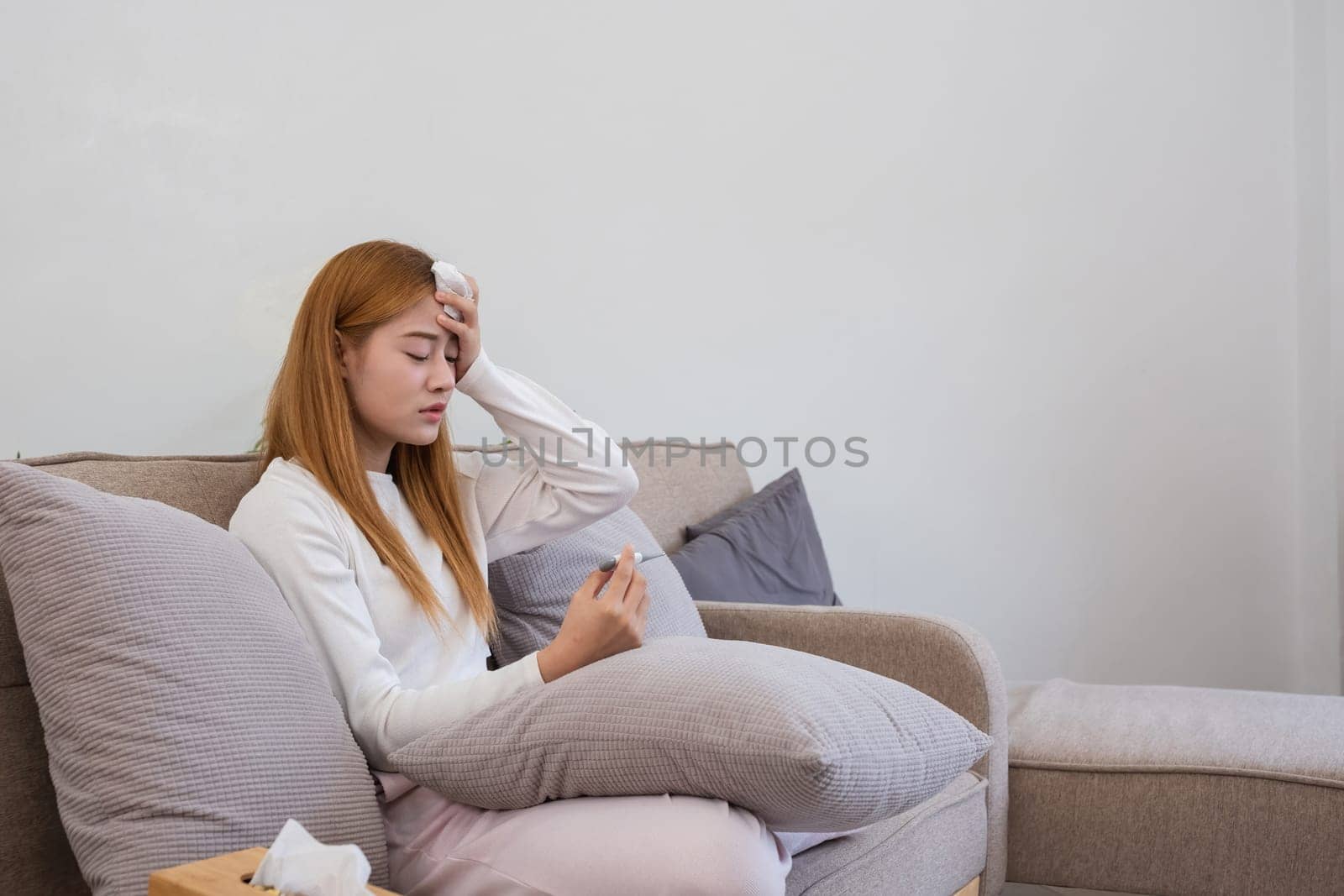 Young Asian woman has headaches from illness or accumulated stress due to health problems and lifestyle problems that cause stress disorder. by wichayada