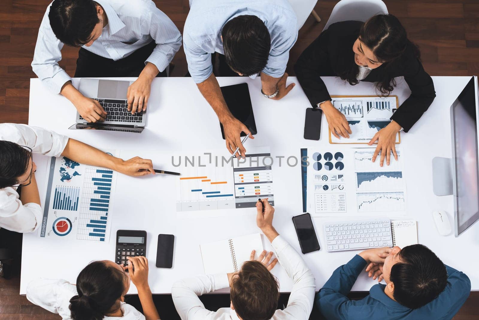 Top view project manager communicate and collaborate with team using project management software, tracking progress of project task and making schedule plan at meeting table. Prudent