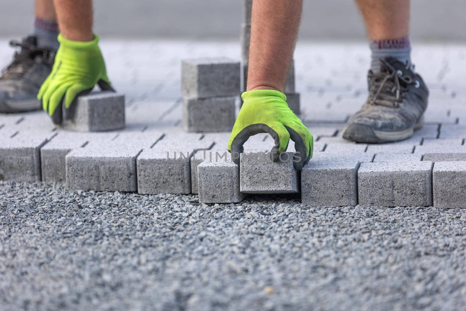 Worker doing new interlocking paving sidewalk made from a concrete blocks