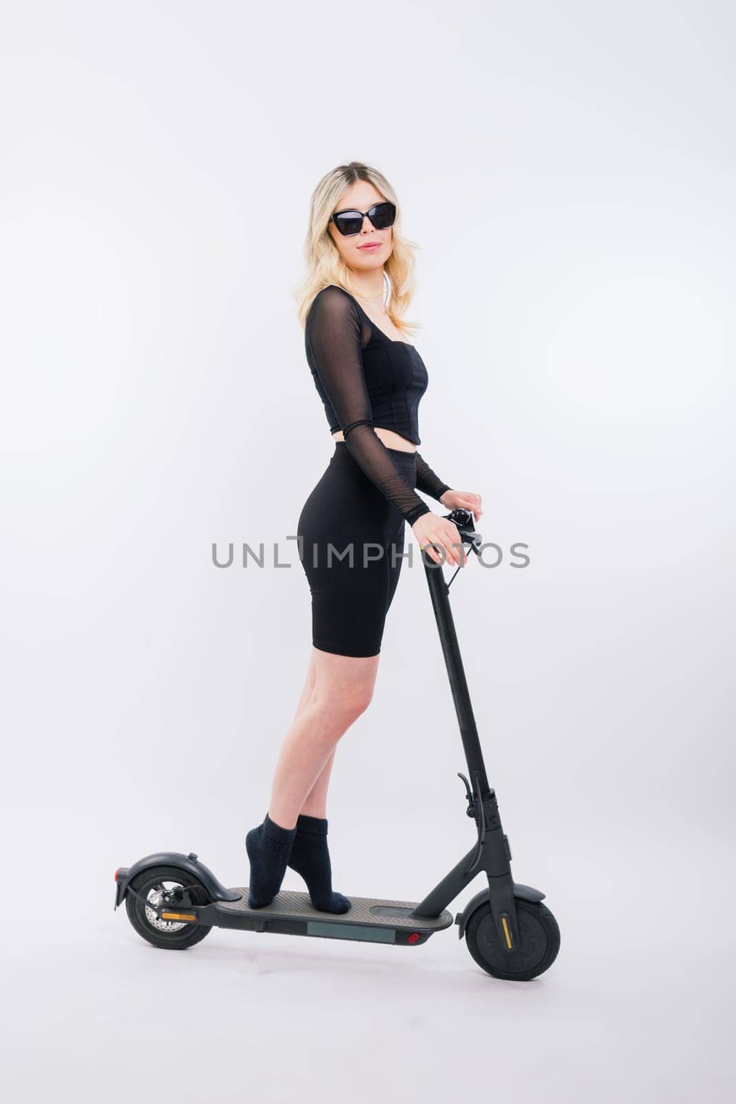 Full body young woman riding electric scooter isolated studio portrait. Lifestyle concept by Zelenin