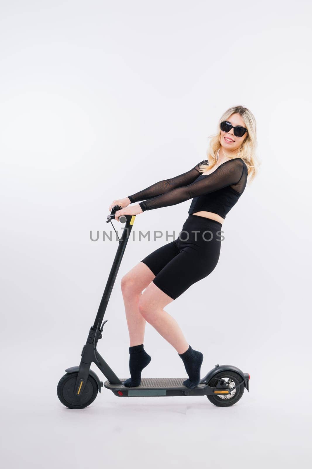 Full body young woman riding electric scooter isolated studio portrait. Lifestyle concept by Zelenin