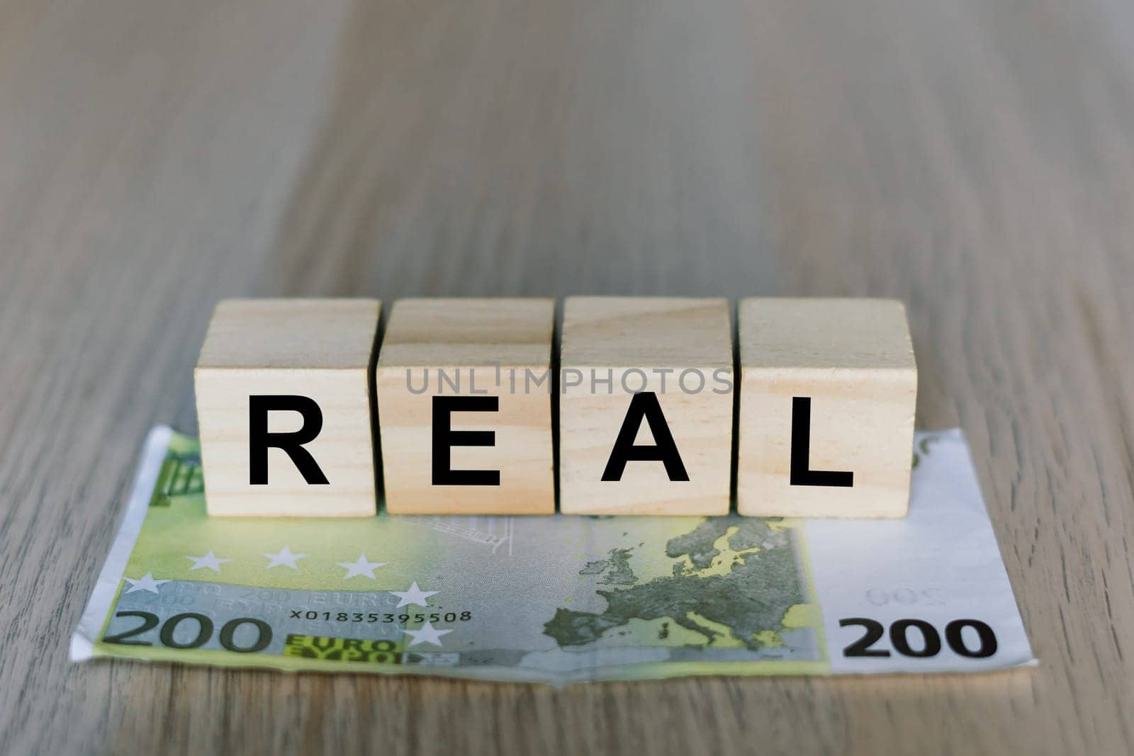 Real word on a wooden cubes blocks, money 200 Euro banknotes. Management big salary career concept.