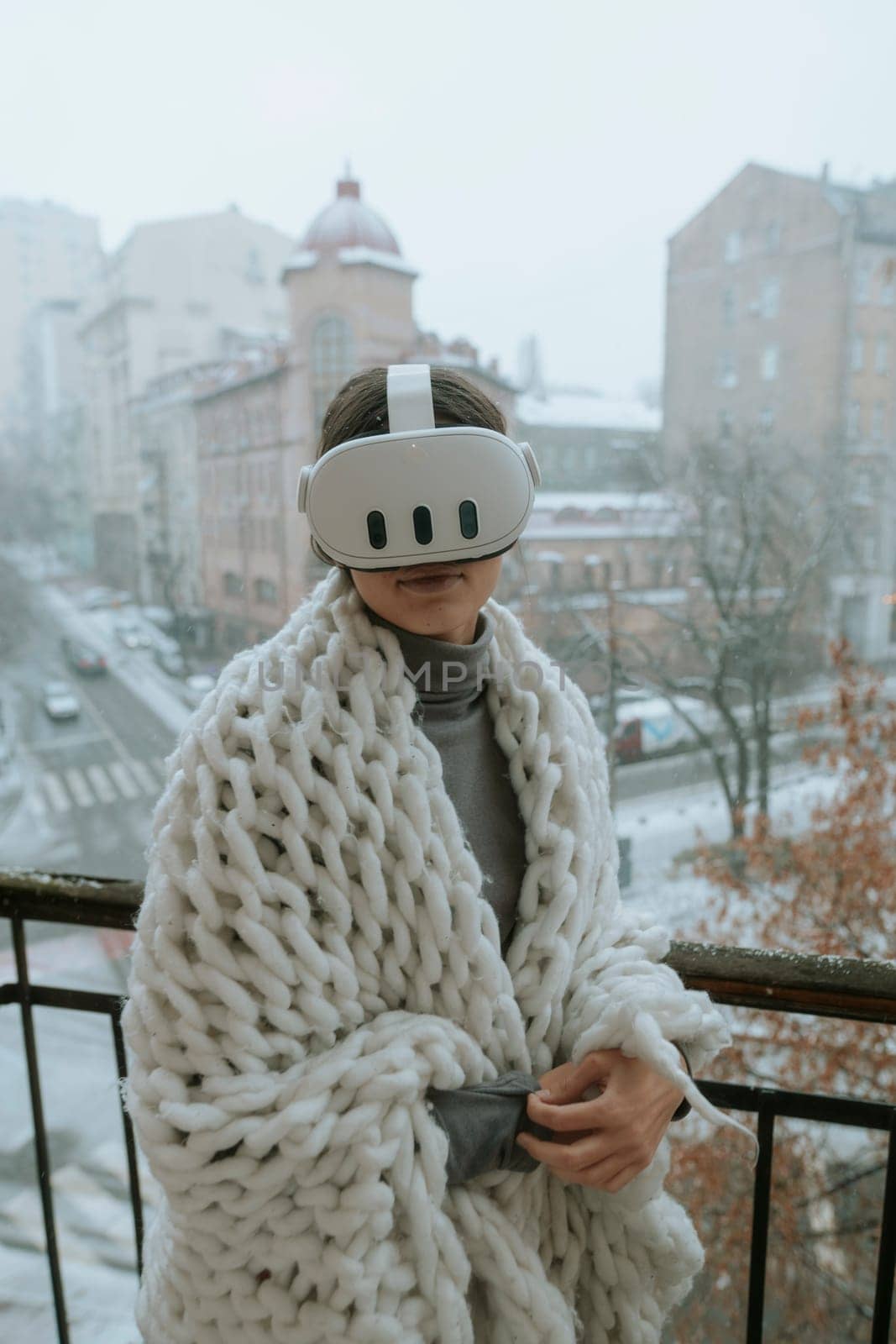 A girl immerses herself in virtual reality on the winter balcony, wearing a headset. by teksomolika