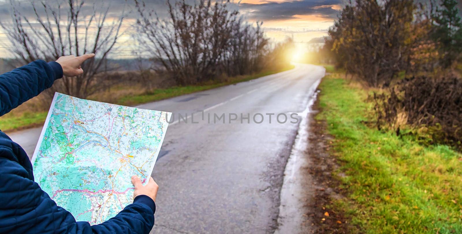 A man looks at a map on the road. Selective focus. People.