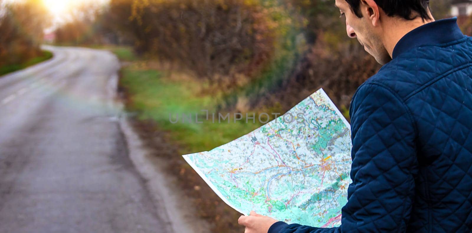 A man looks at a map on the road. Selective focus. People.