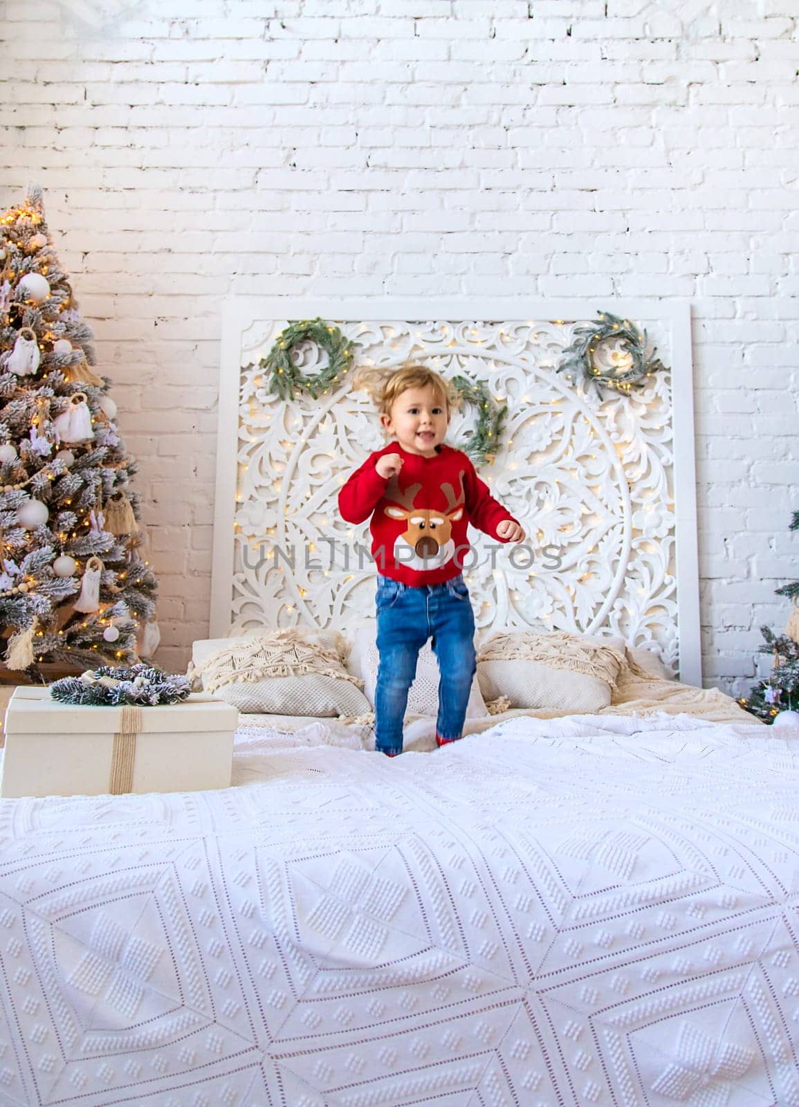 A child dances near a Christmas tree. Selective focus. Kid.