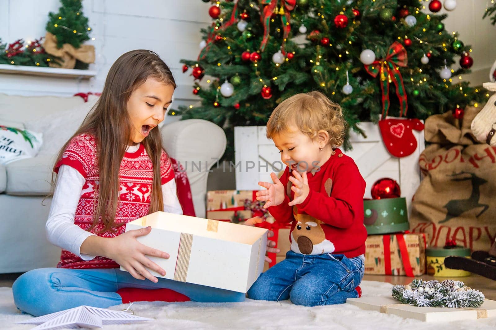 Children open Christmas gifts under the tree. Selective focus. Kid.