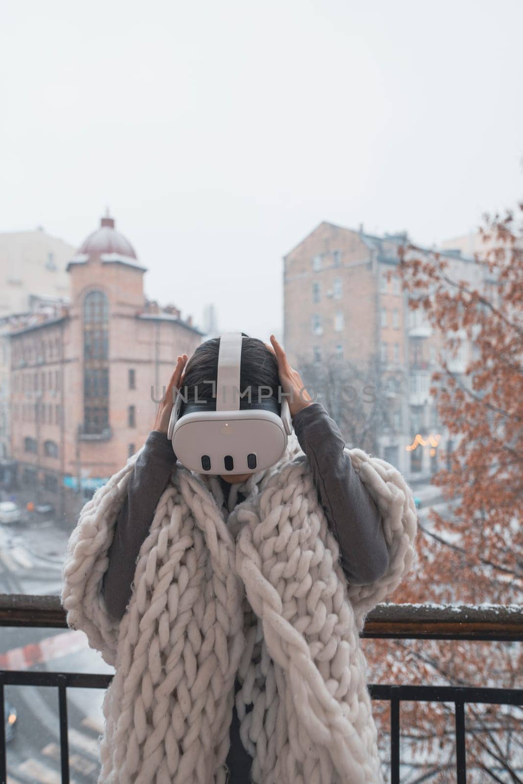 Virtual reality meets the winter city as a girl wears VR glasses against its backdrop. by teksomolika