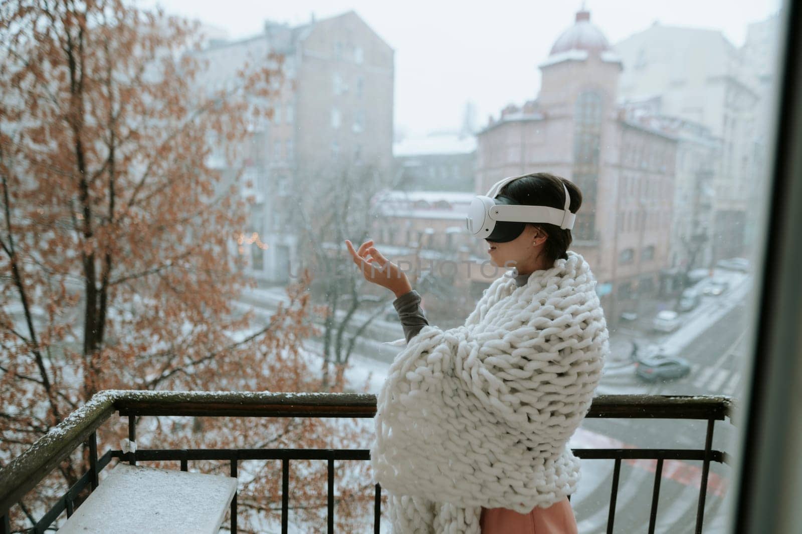 A stunning lady immersed in virtual reality stands amidst the winter city with VR glasses. High quality photo