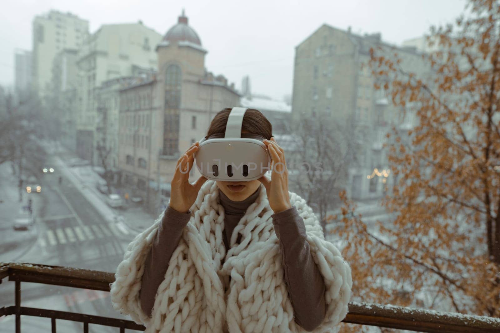 Amidst the winter cityscape, a lovely lady experiences virtual reality with VR glasses. High quality photo