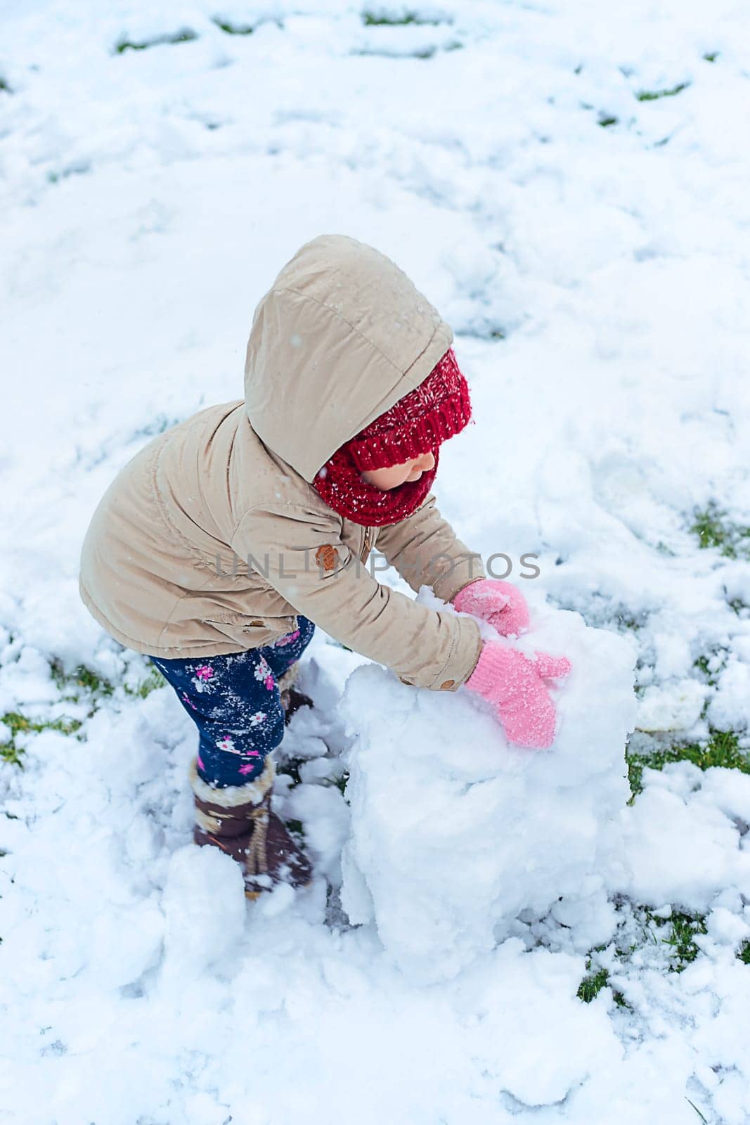 Children make a snowman in winter. Selective focus. Kid.