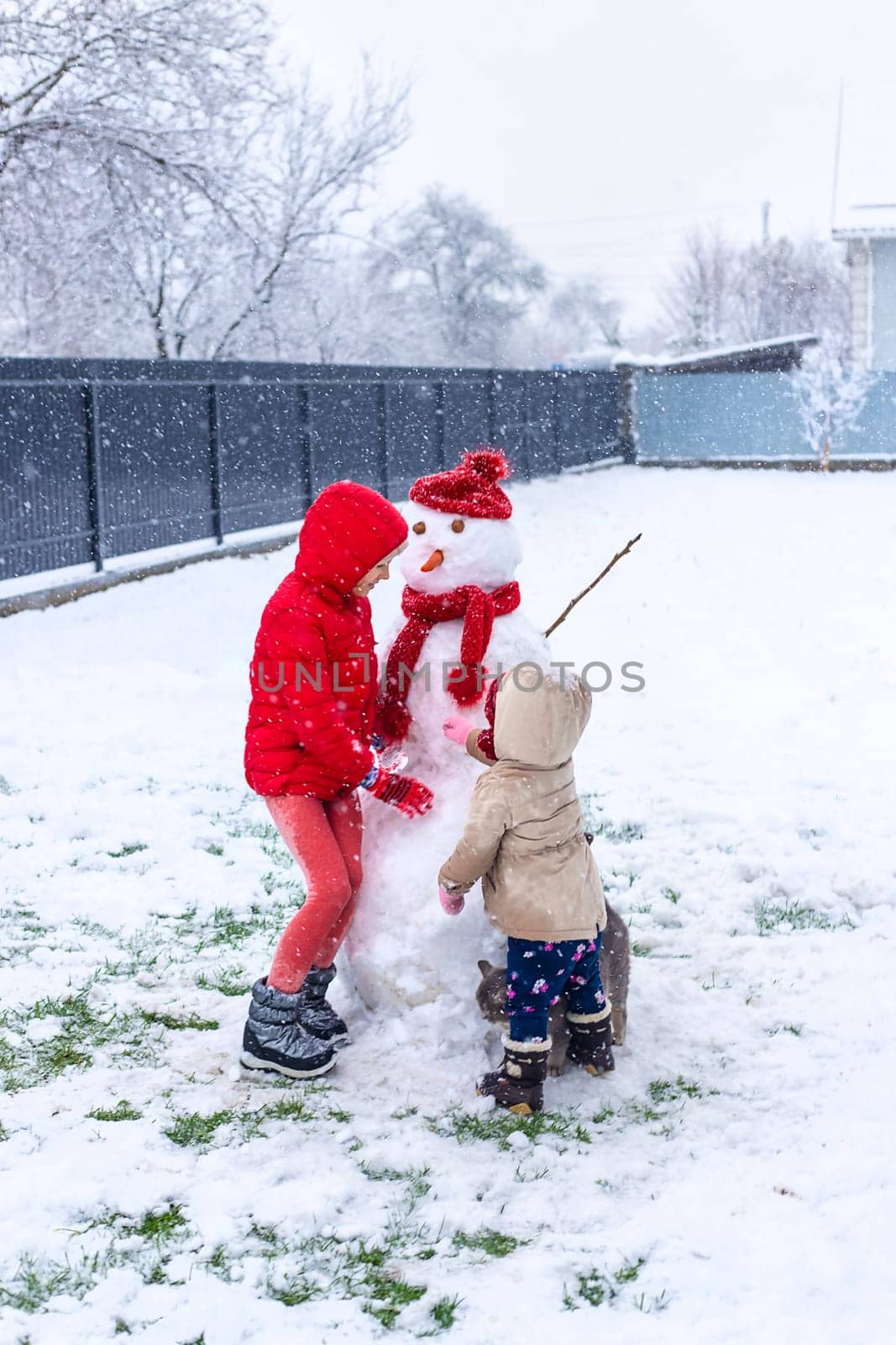 Children make a snowman in winter. Selective focus. Kid.