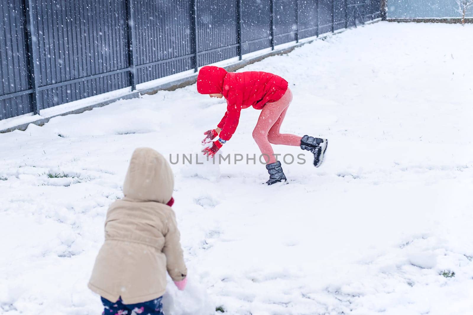 Children make a snowman in winter. Selective focus. Kid.