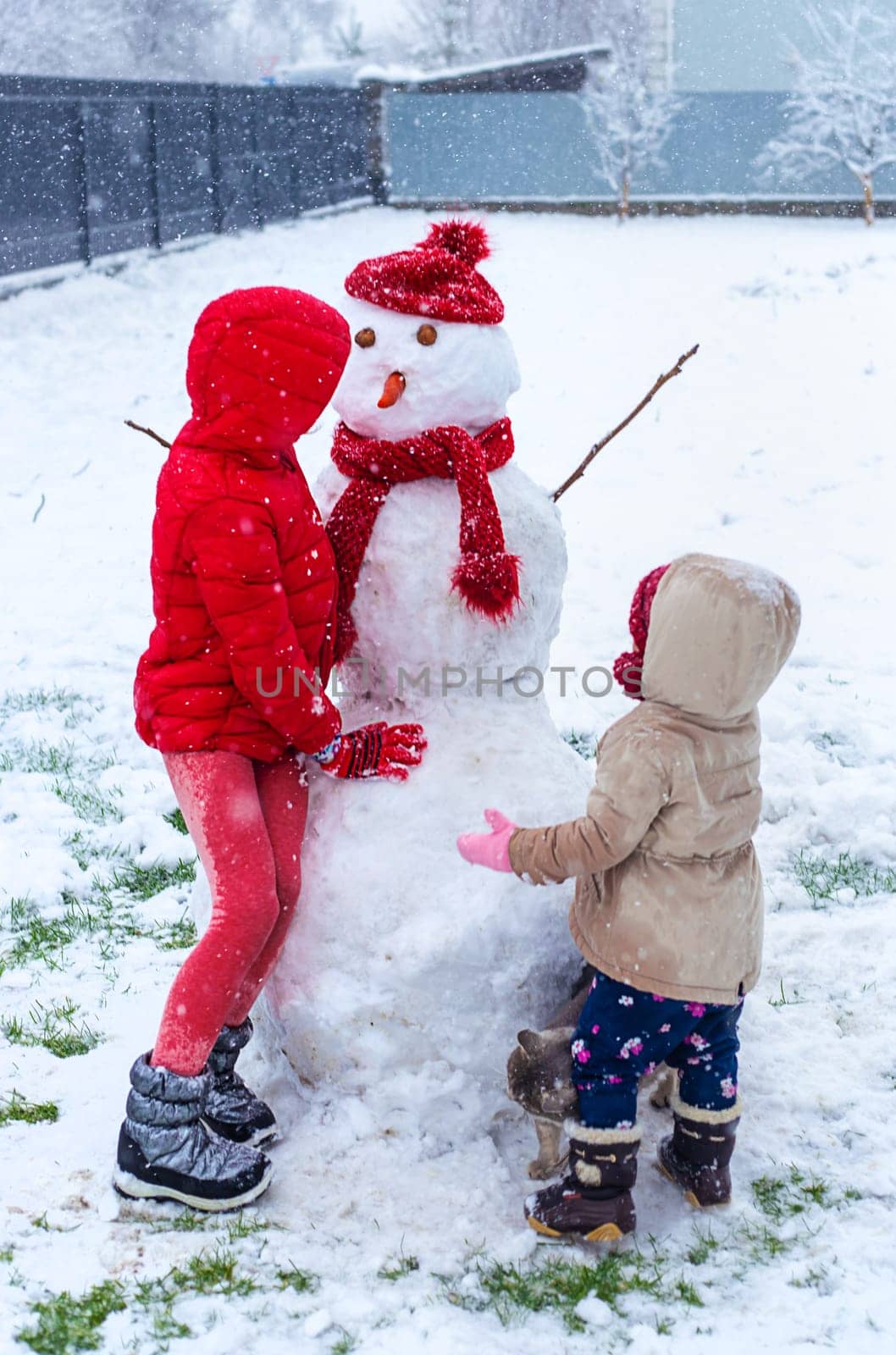 Children make a snowman in winter. Selective focus. Kid.