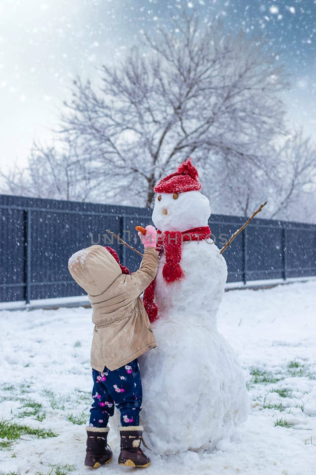 Children make a snowman in winter. Selective focus. Kid.