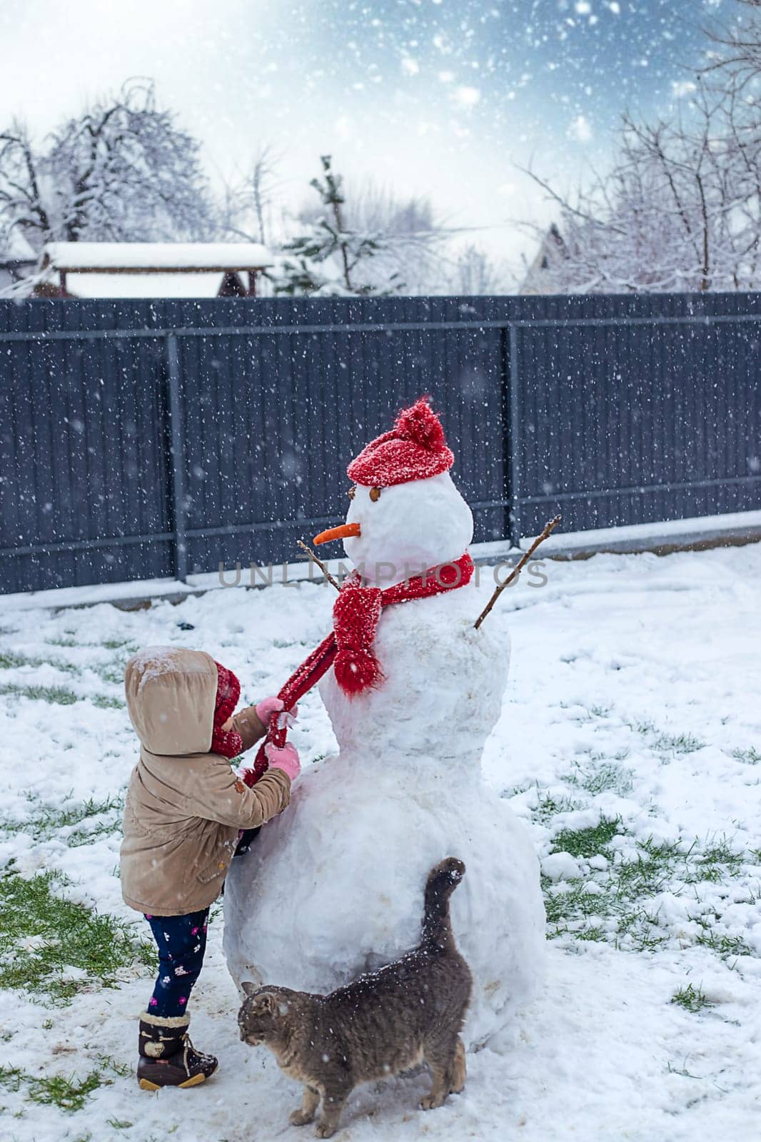 Children make a snowman in winter. Selective focus. Kid.