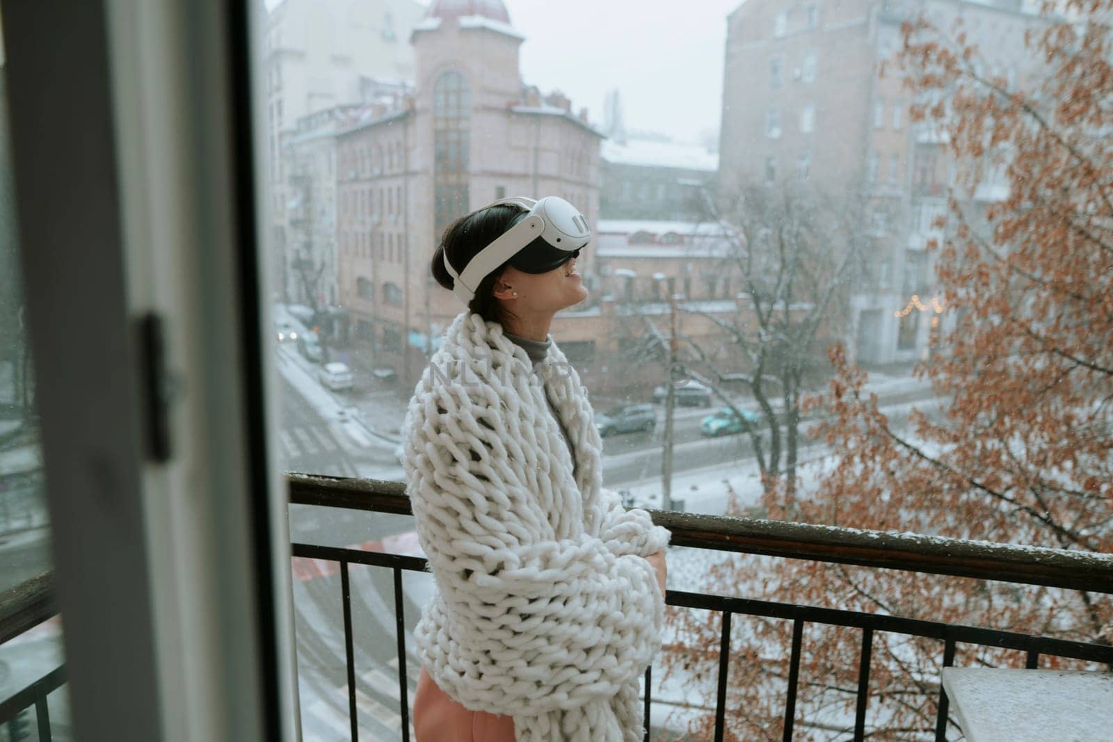 Engrossed in virtual reality, a girl stands against the backdrop of the winter city. High quality photo