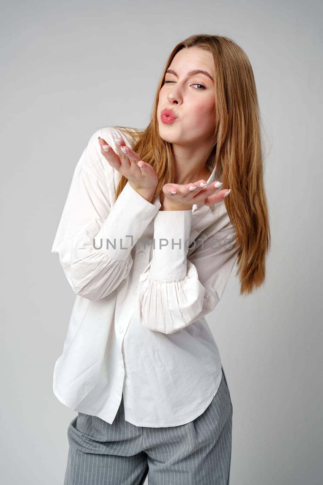 Young Woman Blowing a Kiss Towards the Camera in a Studio close up