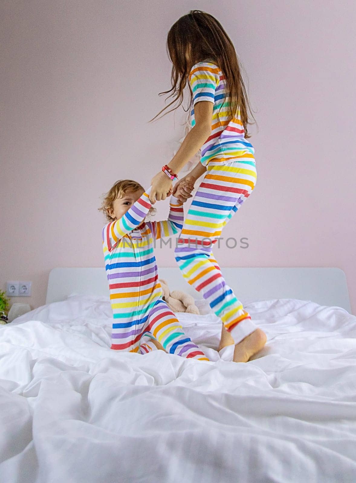 Children play jumping in bed. Selective focus. Kid.