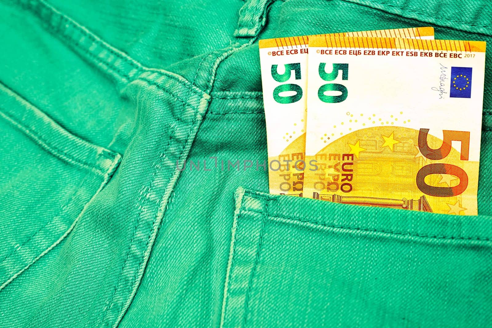 Money, shopping, stash. Two 50 euro banknote in green jeans by jovani68