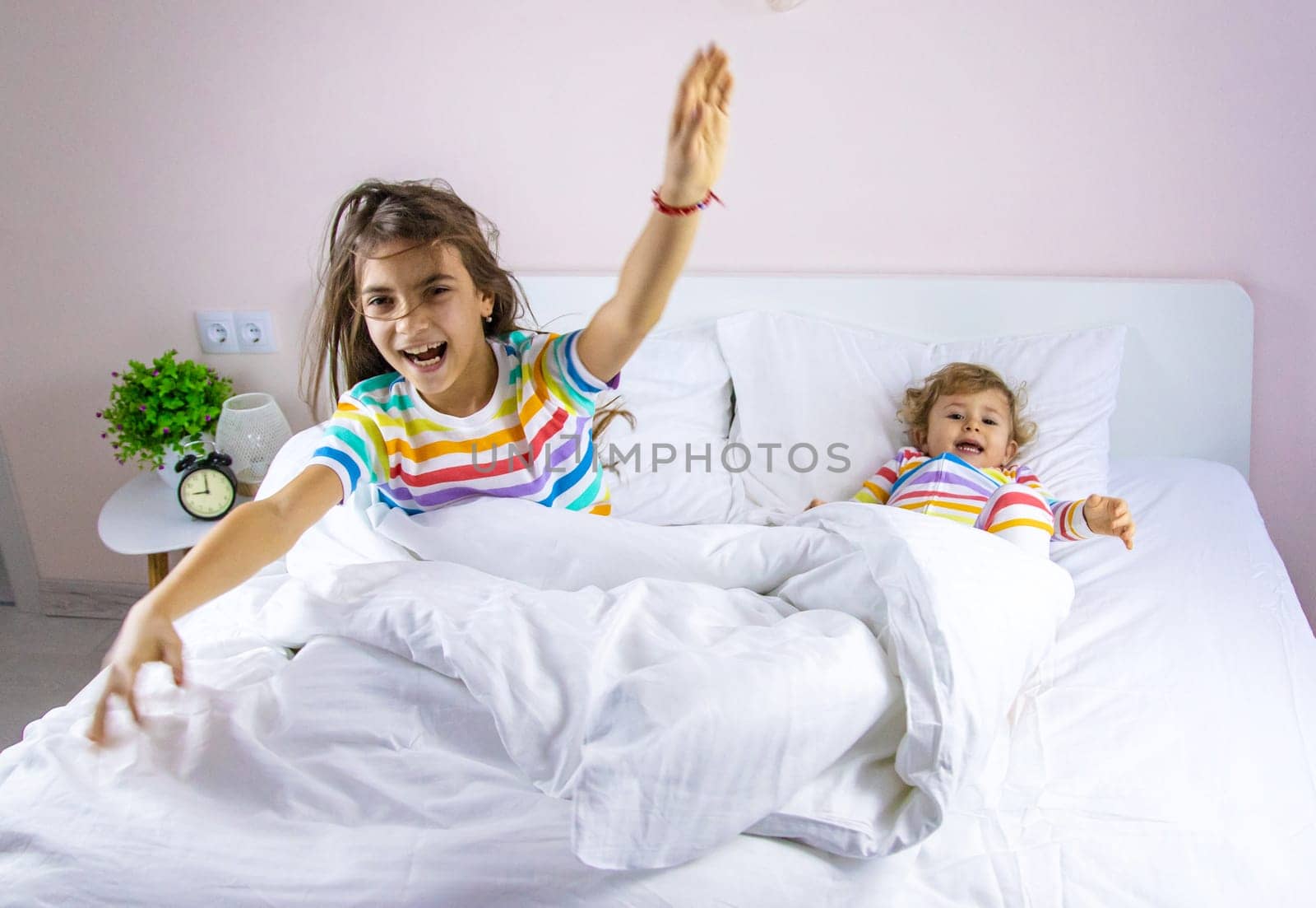 Children play jumping in bed. Selective focus. Kid.