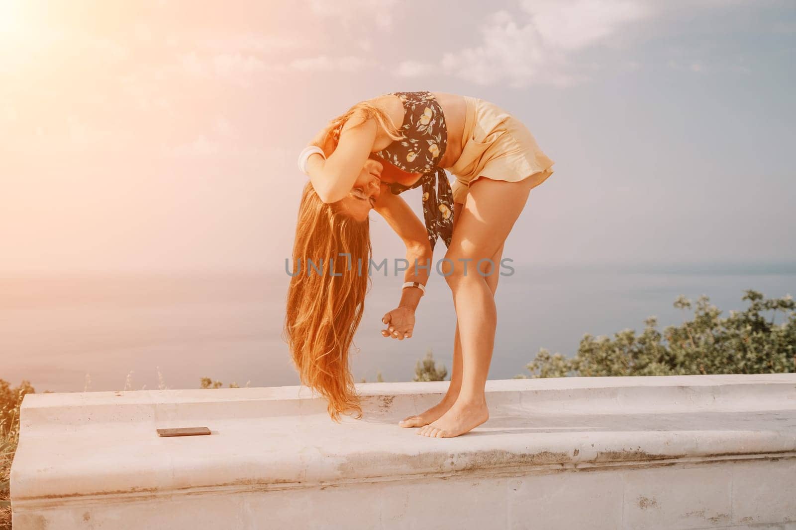 Woman park yoga. Side view of free calm bliss satisfied woman with long hair standing in morning park with yoga position against of sky by the sea. Healthy lifestyle outdoors in park, fitness concept