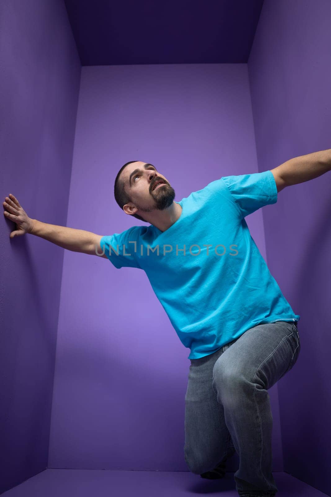 Young man isolated on purple background thinking and looking up. by PaulCarr