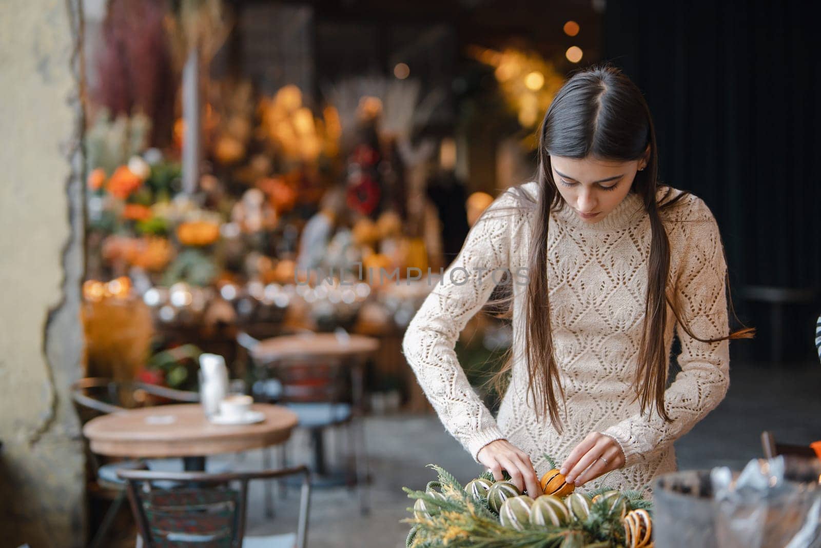 A radiant young woman fully immersed in a Christmas decor DIY workshop. High quality photo