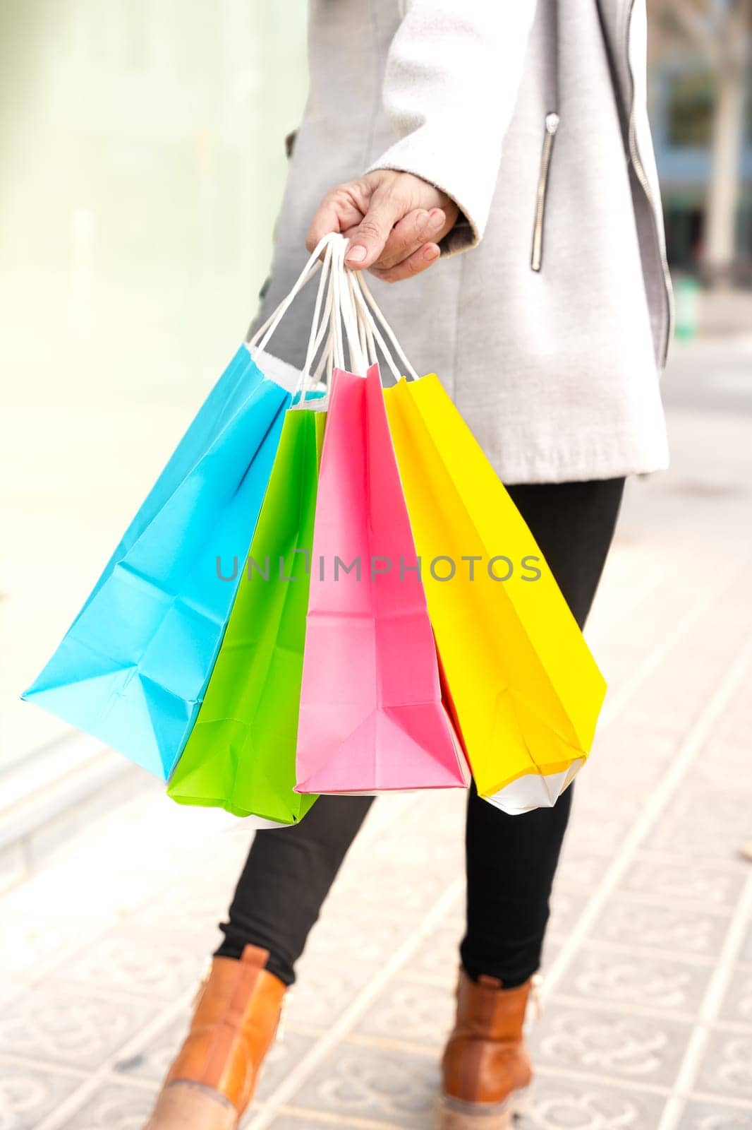 Vertical portrait unrecognizable woman with shopping bags outdoors. by mariaphoto3