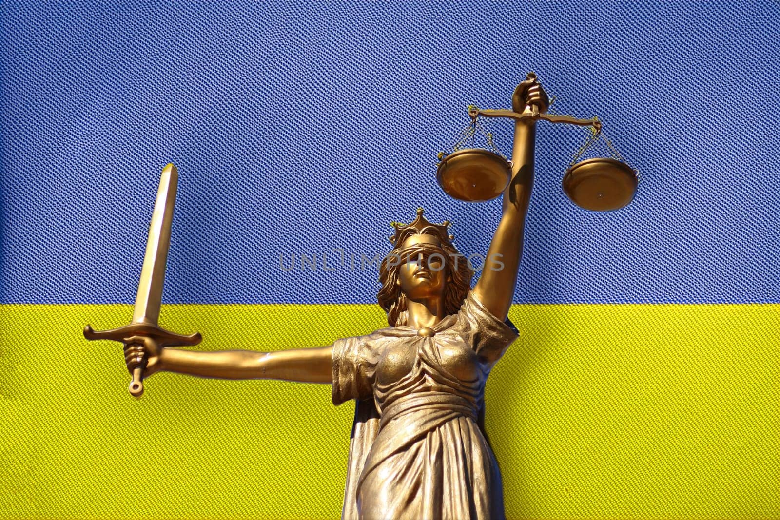 Gerechtigkeit, das Symbol der Gerechtigkeit mit Schwert und Waage vor der ukrainischen Flagge.