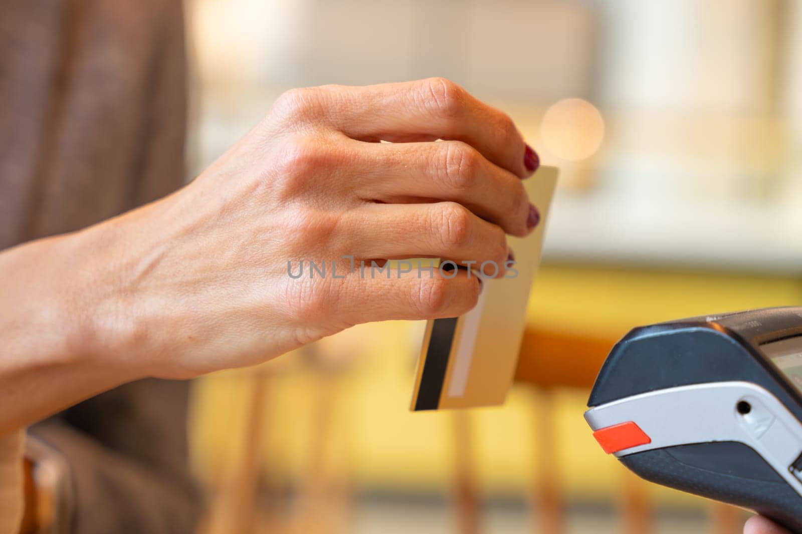 Close-up Hand of a young woman holding a credit card and making a payment transaction.