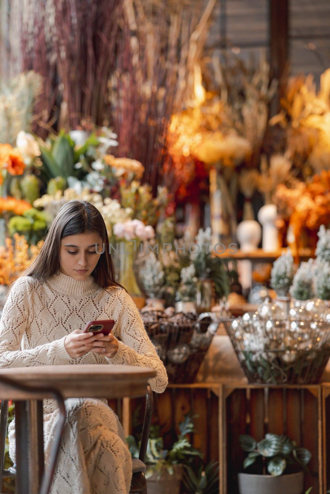 A charming, colorful young lady taking photos of holiday decorations with her smartphone. High quality photo