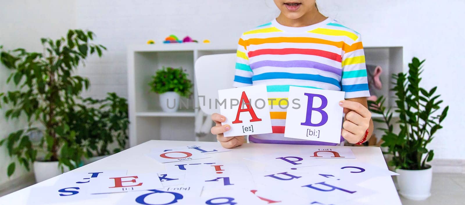 The child learns English letters. Selective focus. Kid.