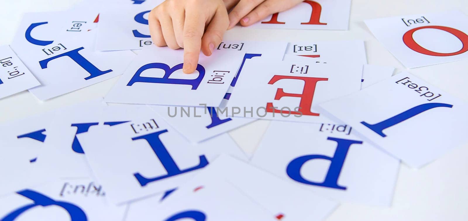 The child learns English letters. Selective focus. Kid.