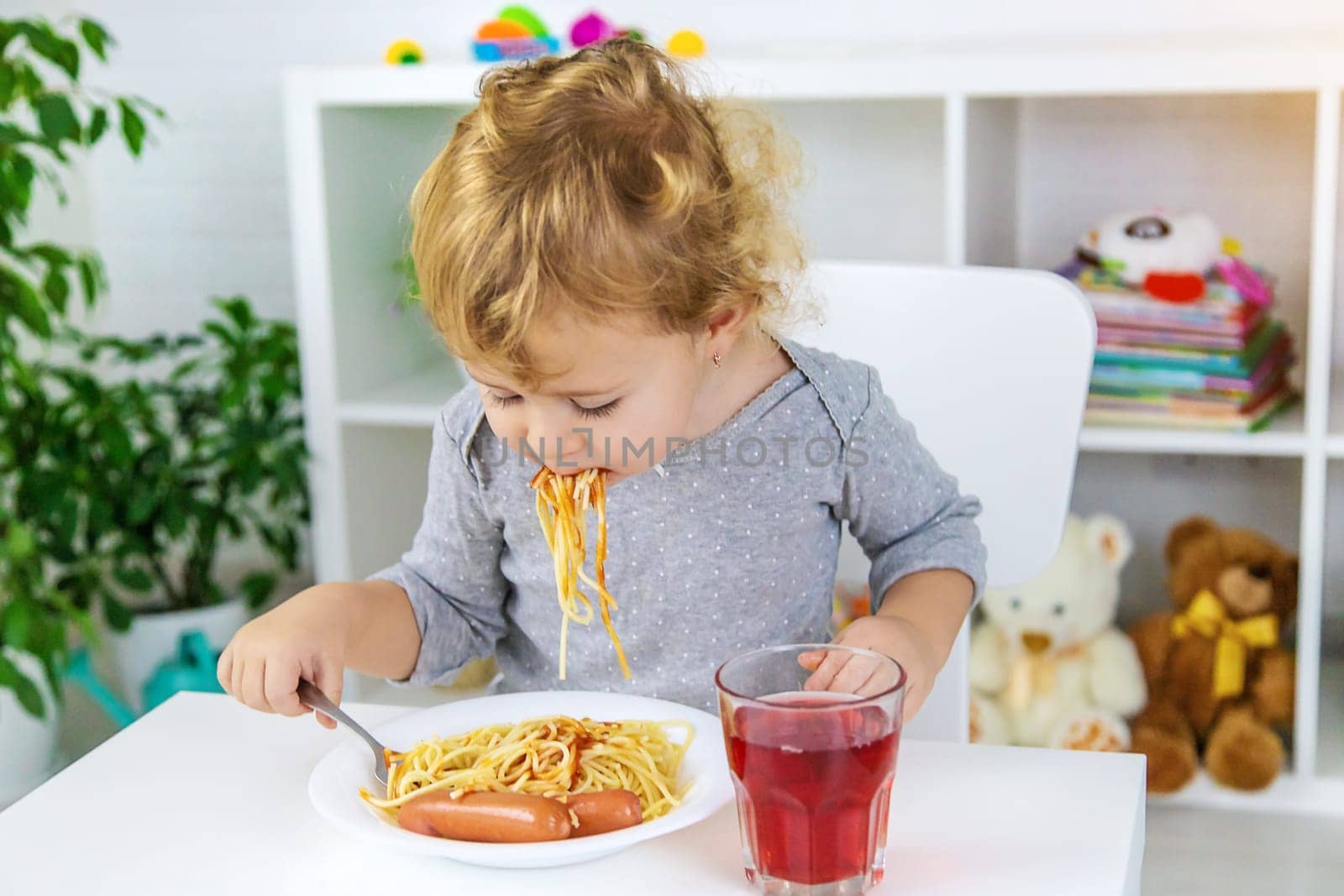 The child eats spaghetti lunch. Selective focus. Food.