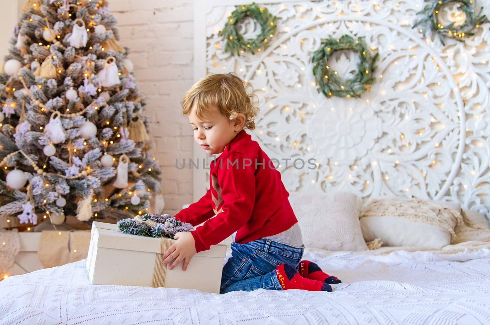 Child open Christmas gifts under the tree. Selective focus. Kid.