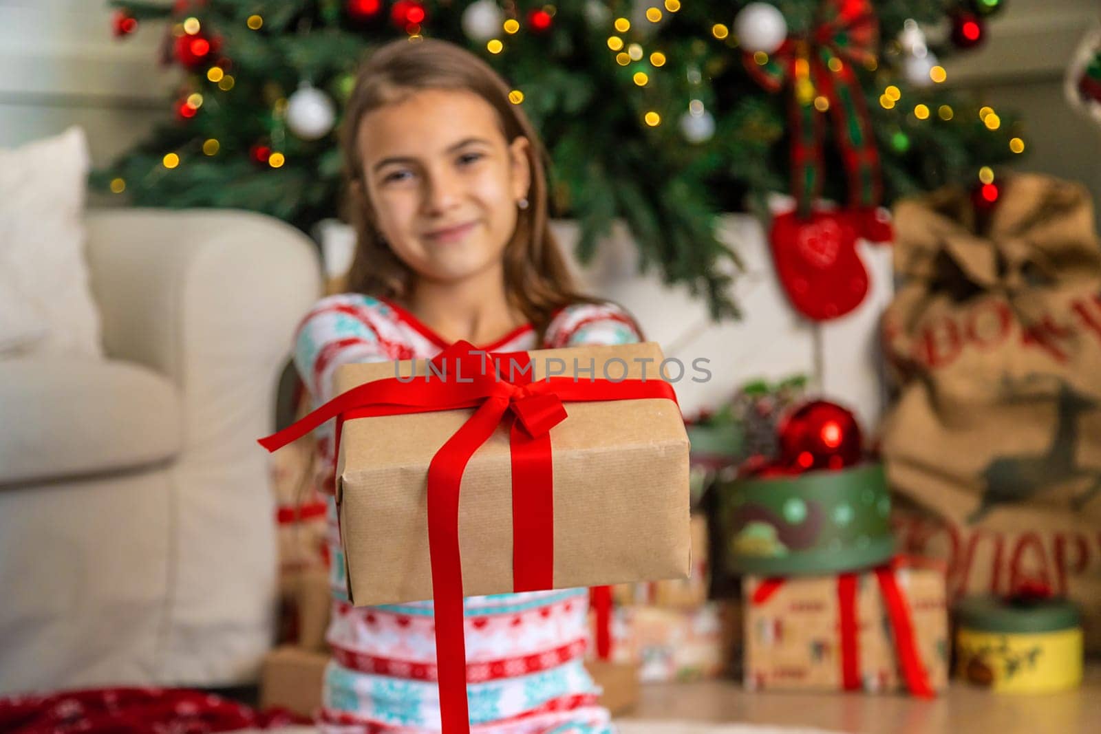 Children near the Christmas tree with a gift. Selective focus. Kid.