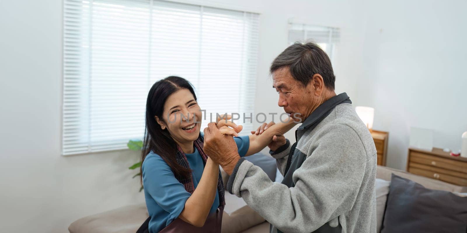 Happy Senior Couple Dancing at Home in a Bright Living Room. Activity Senior concept