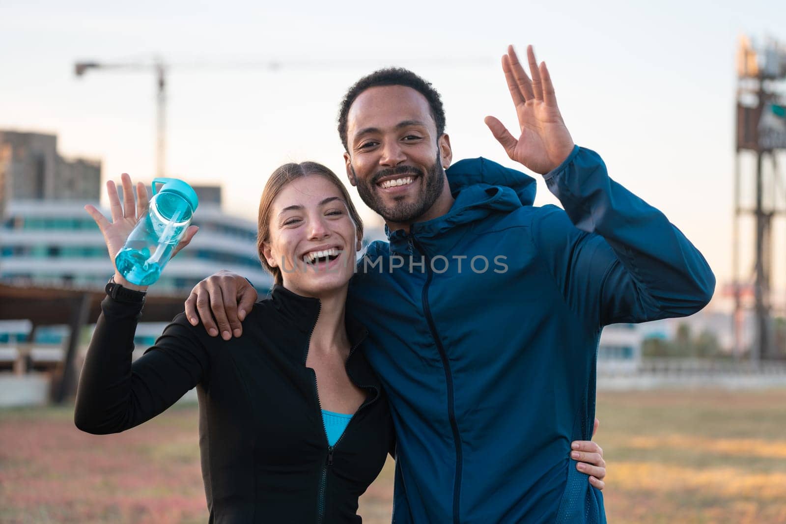 Portrait happy young couple ready to exercise outdoors. by mariaphoto3