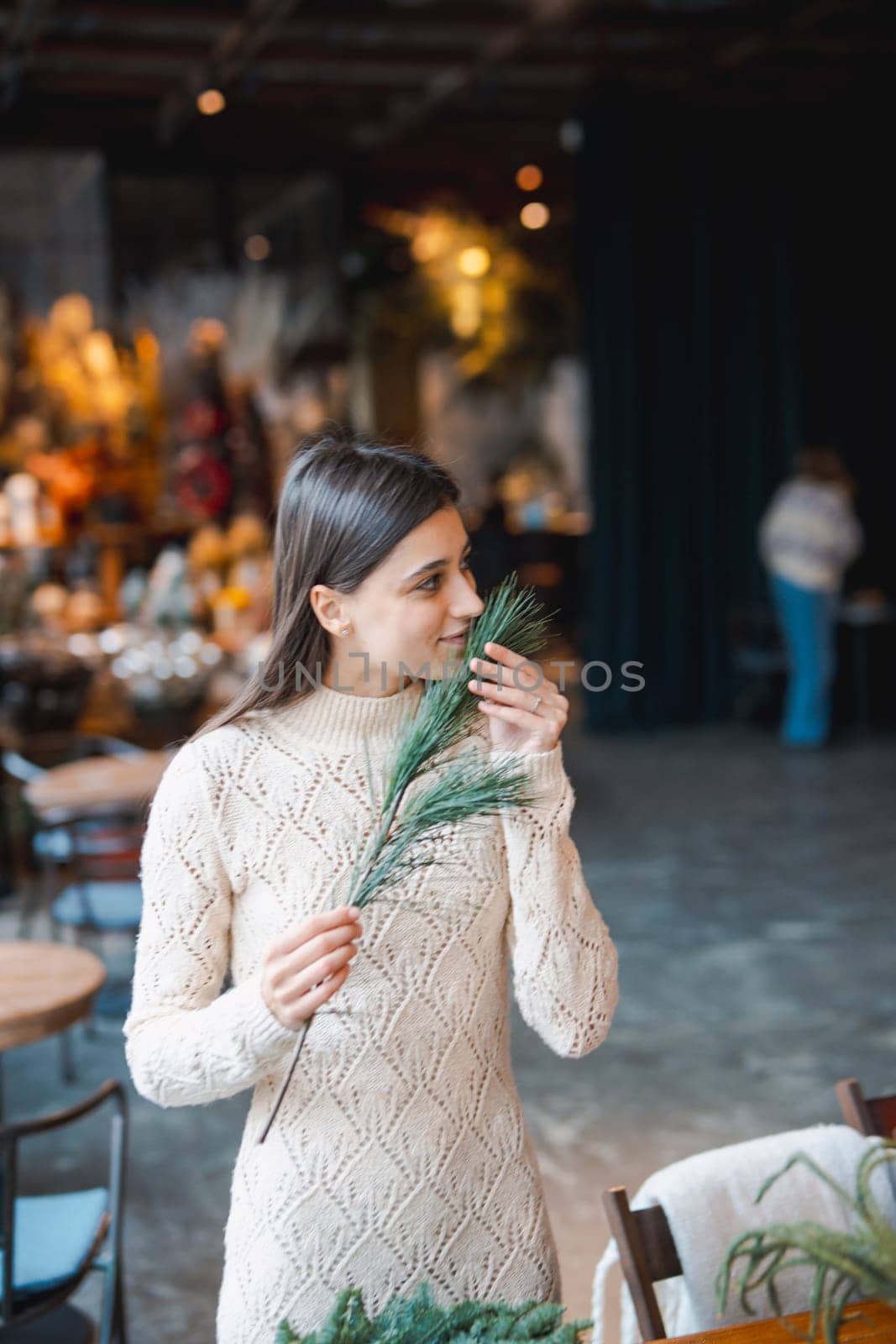 A young woman crafting a festive wreath during a decor-making seminar. High quality photo